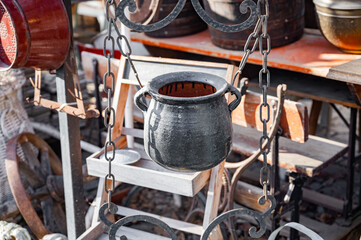 Antique store, flea market, junk and vintage items. iron pot hanging on a chain