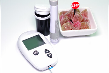 stop sugar concept for diabetic, fruits candy with blood glucose testing equipment on a isolated white.