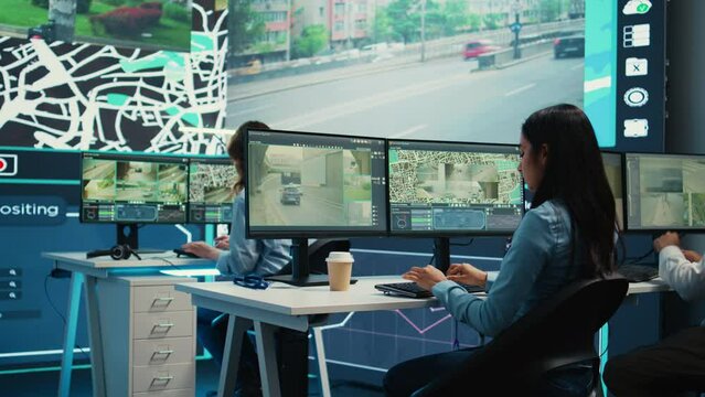 Indian shipping agency employee gathering data on traffic via surveillance footage, helping delivery trucks with cargo for shipment. Operator uses gps coordinates for tracking orders. Camera B.