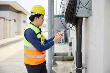 male worker checking electrical control panel in the factory