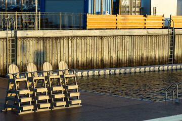 Lifeguard chairs on the edge of the Port of Québec Oasis, the first harbour bath in North America, deserted during a sunny spring morning, Quebec City, Quebec, Canada