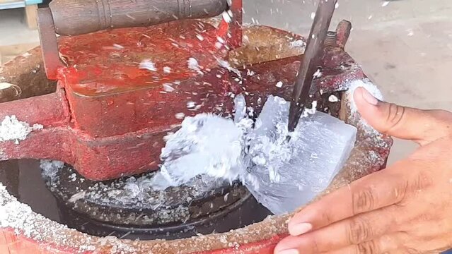 Slow Motion Footage A man puts ice on an ice cream machine and breaks it. How to make Qulfa. Manual kulfa making machine in pakistan. The breaking of the ice. Beautiful 4K footage.
