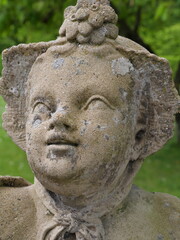 Gesicht einer barocken Steinstatue einer Putte (Engel) im Schloßgarten Veitshöchheim (Bayern,...