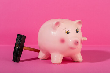 Pink piggy bank with small hammer