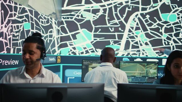 Diverse dispatch operators giving real time updates on order delivery and shipment, working in call center observation room. Employees guiding couriers around the city, CCTV footage. Camera B.