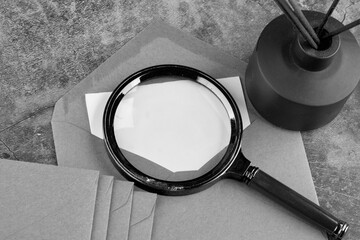The concept of secret document research. A magnifying glass on a note from an envelope with a place...