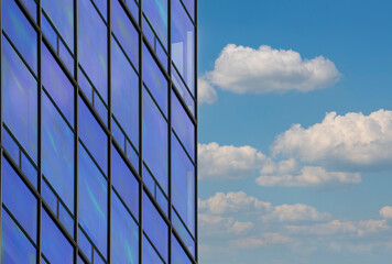 blue glass wall of skyscraper and clouds