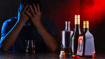Bottles with alcoholic beverages and the figure of a drunk man
