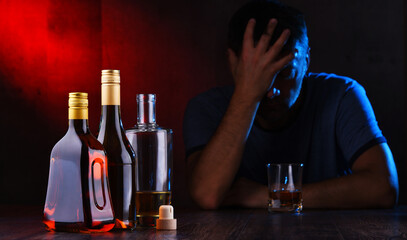 Bottles with alcoholic beverages and the figure of a drunk man