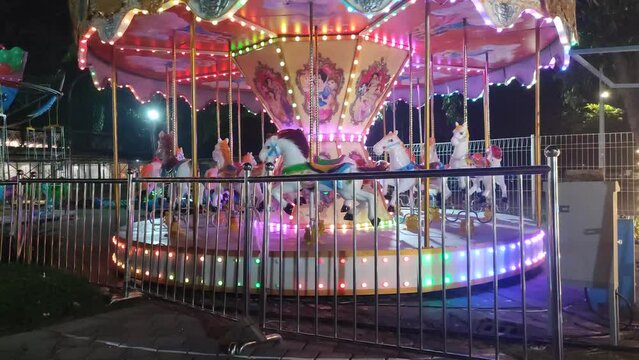 The carousel with sparkling colorful lights rotates until it stops without anyone at food junction amusement park on surabaya east java indonesia.