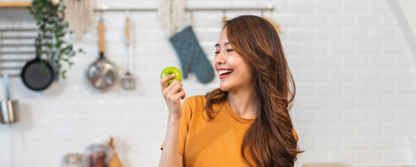 Portrait of beauty body slim healthy asian woman big smile cooking and preparing vegan food healthy holding apple, green apple, dental, teeth, fruit in kitchen at home.Diet.Fitness, healthy food