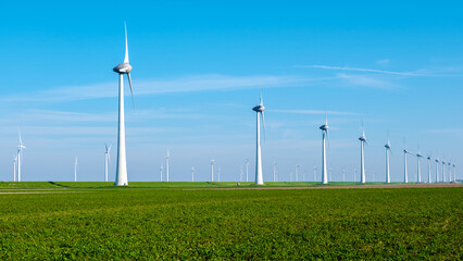 A row of majestic wind turbines standing tall in a lush, green field of the Netherlands Flevoland,...