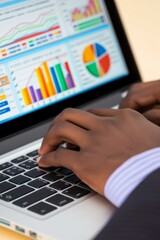 A business person of African descent is typing on a laptop.