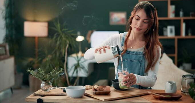 Woman, cooking and health drink with matcha and green tea ingredient in kitchen. Relax, smoothie and nutrition at morning with breakfast and detox in home on table with nutritionist and clean eating