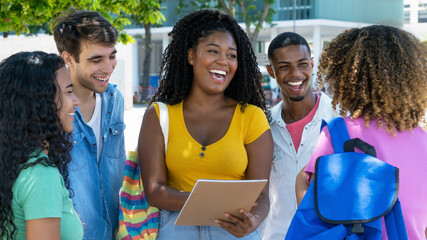 Group of laughing black and latin american and caucasian male and female students