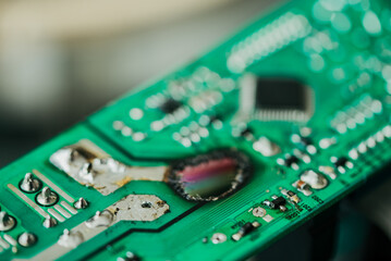 Close-up of a damaged electronic circuit board with components and solder, selective focus. Repair of kitchen appliances, a burnt-out control unit.