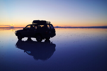 Silhouette of a Van on the Mirror Effect, a Shallow Flooding of Uyuni Salts Flats in Potosi...