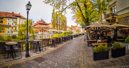 Street view Ljubljana - Cobblestone Street With Tables and Umbrellas
