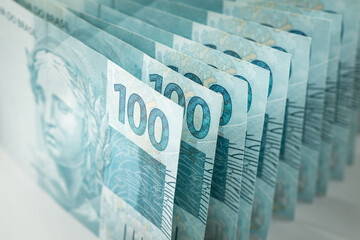 Brazil money, Stack of 100 reais banknotes standing in harmony vertically on the table, Business concept