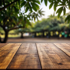Empty wooden table for product display with mango trees blurred background and a few mangos
