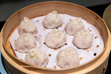 Authentic Steamed Xiaolongbao on Parchment in a Bamboo Steamer, Ready to Serve