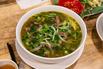Classic Pho Bo: Vietnamese Beef Noodle Soup Served with Fresh Basil and Lime in an Aromatic Broth