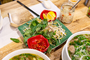 Essential Fresh Ingredients for Vietnamese Pho: Basil, Bean Sprouts, Lime, and Pickles to Enhance...