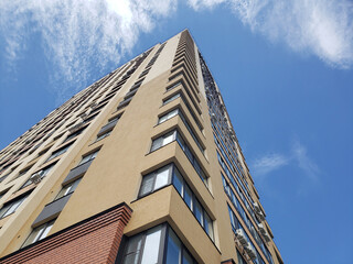 high-rise apartment building against the blue sky. Typical developments in residential areas.