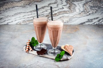 Traditional chocolate milk shake with chocolate sauce and vanilla ice cream served in a glass with...