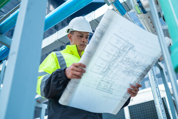 Engineer reads asbuil drawings to inspect chiller water pipes