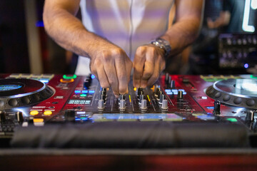 DJ's Hands Adjusting Music Mixer at Event