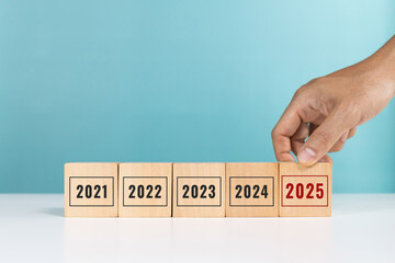 2025 goal planning. Happy new year 2025. Start of year. Hand put wooden cubes with number 2025...