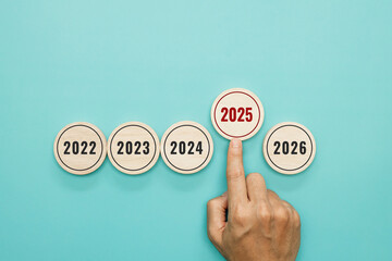 2025 goal planning. Happy new year 2025. Start of year. Hand pointing wooden with number 2025 while at the table in the office