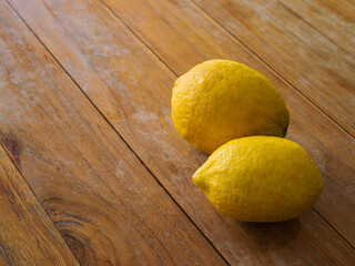 Fresh yellow lemon fruits on wood texture table.  Fruits or food concept.