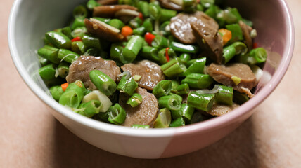 Stir-fried beans in a bowl placed on the table. Top Angle. Close up.
