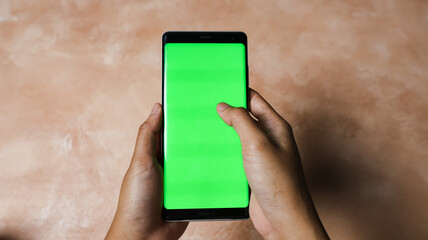 Two hands are holding a smartphone with green chroma key. Smartphone Green Screen.