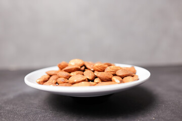 A bunch of almonds placed on a white plate.