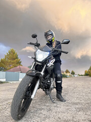 woman motorcyclist in a helmet, motorcycle gloves, motorcycle boots on a motorcycle close-up