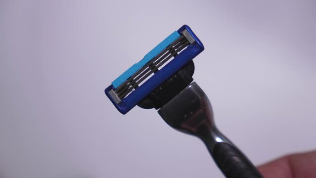 ATUMI, GEORGIA - APRIL 11, 2024: Shaving machine with used cassette or head. Gillette is brand of men's safety razors. Male hand holding car and showing used cassette