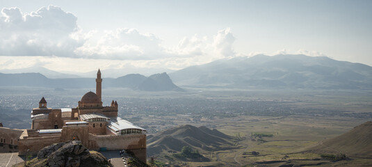 Historical Arabian palace with minarets overlooking city in the valley beneath, Eastern Turkey