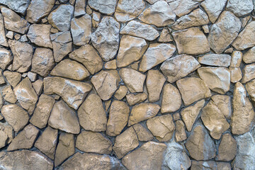 Old wall made of uneven natural stones. Abstract construction background.