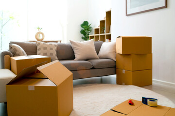 cardboard box moving new home place in living room. open and close packaging in room concept of relocating or changing home. decoration in room include sofa plant and box for moving out other places