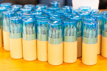 Small colored pencils in yellow cylinders equipped with sharpeners