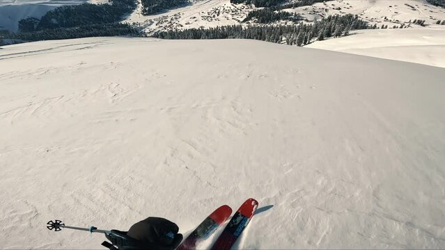  Freeride skiing down the untouched terrain of a remote mountain in wilderness. Riding in fresh powder snow