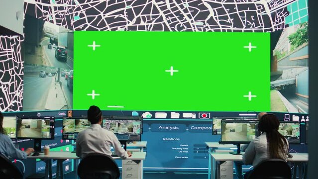 Shipping agency workers examine satellite map with huge greenscreen display, monitoring parcels and orders for clients. Employees using surveillance CCTV footage to get updates. Camera B.
