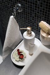 Soap dispenser bottle and hand cream on tray in hotel bathroom