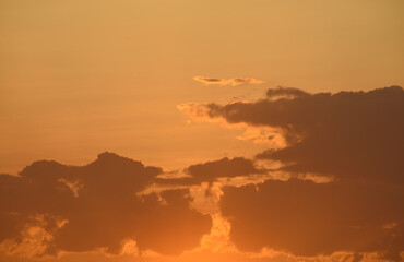 Colorful sunset in the evening. The setting disk of the sun over the forest. Clouds and a yellow sunset.