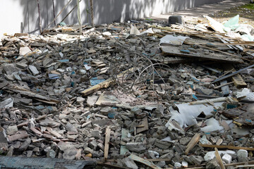 Construction waste. A pile of concrete debris with reinforcement, boards and pieces of wire after...