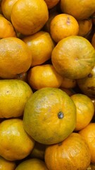 Close up pile of tasty fresh oranges sold at the market as a background.