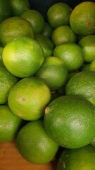 Close up pile of tasty fresh limes sold at the market as a background.